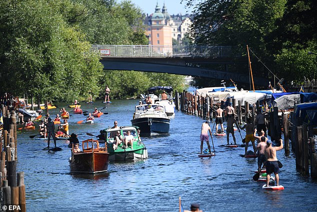 People enjoy boat rides, canoe paddling and stand up paddle in the nearly 30 degrees Celsius summer weather at the Palsund canal in Stockholm, Sweden in early August. The country has been unique for its liberal approach to the virus, avoiding locking the country down