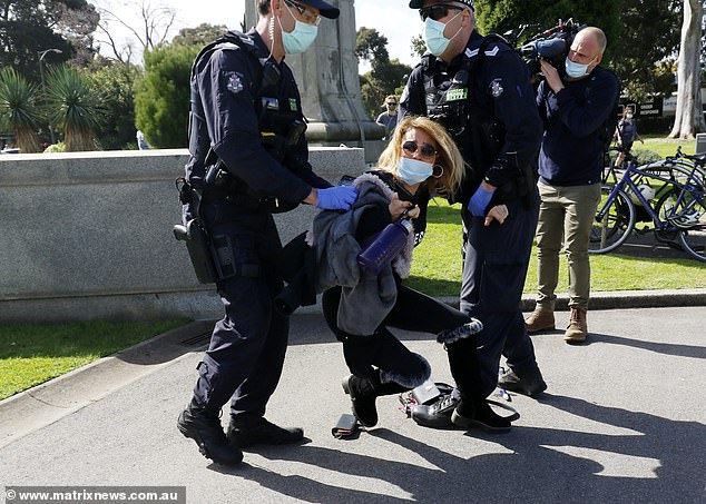 One woman with a top reading: 'Freedom' was seen being dragged away by two police officers and she desperately tried to fight them off
