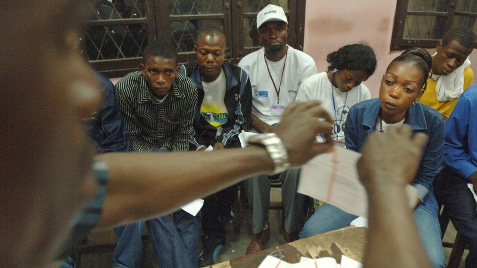 An official raises a used ballot paper while counting votes during an election in the Democratic Republic of Congo, 29 October 2006