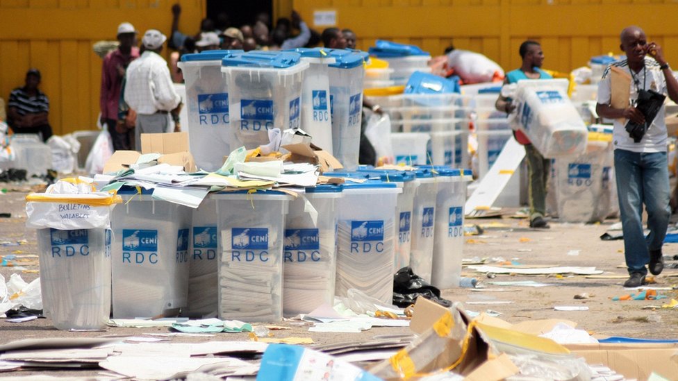 Electoral agents of the National Independent Electoral Commission (CENI) alongside ballot boxes in the Democratic Republic of Congo, 2 December, 2011