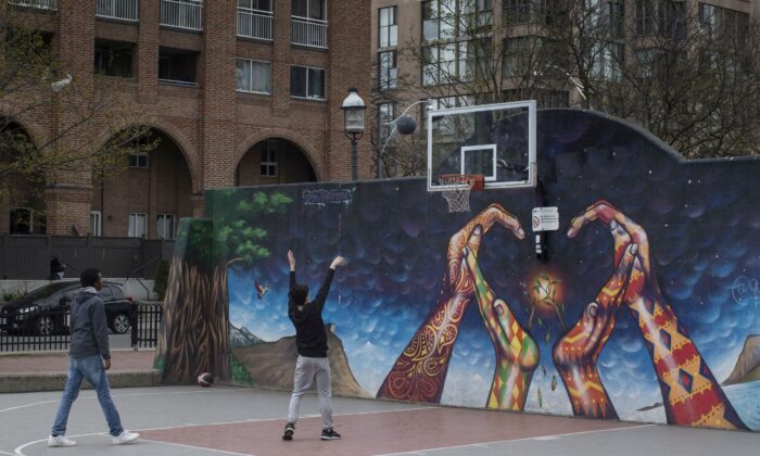Two youths play basketball in an otherwise quiet court in Toronto on April 17, 2021. (The Canadian Press/Chris Young)