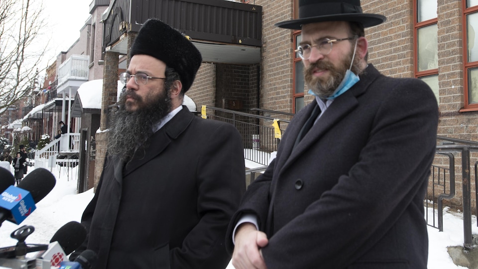 Deux hommes du Conseil des juifs hassidiques du Québec sur un trottoir de Montréal en hiver.